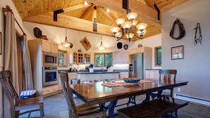 A spacious kitchen with wooden cabinets, a central island, and a dining area with a large wooden table and chairs. - 90ST1 | Dog Friendly | Private Hot Tub | Short Walk to Slopes | Winter Shuttle (Steamboat Springs)