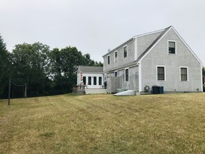 A two-story house with a front porch and a small deck.