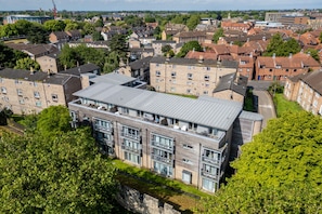 A multi-story building with a flat roof, large windows, and a central courtyard.