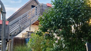 Una casa moderna con una escalera de madera y un jardín lleno de flores.