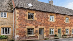 A traditional brick cottage with a stone foundation, multiple windows, and a door. - Poppy Cottage - sleeps 4 guests  in 2 bedrooms (Broadwell)
