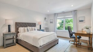 A bedroom with a large bed, bedside tables, a desk, and a chair. - Modern Coastal Farmhouse style home with a private pool, open-floor plan,... (Sag Harbor)