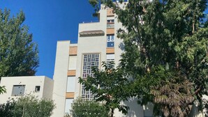 A modern building with a flat roof, large windows, and a central courtyard.