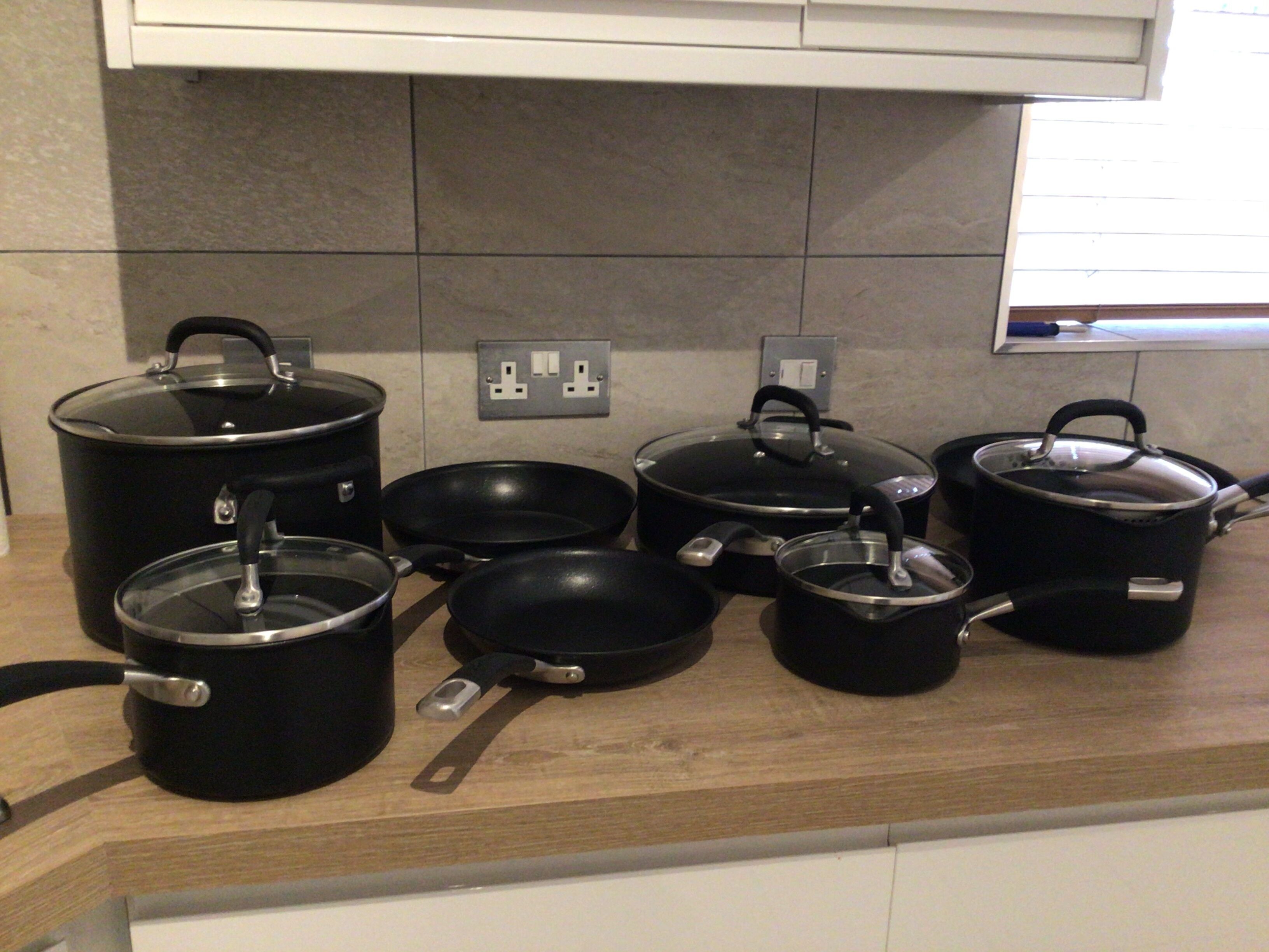 Una encimera de cocina con varias ollas y sartenes.