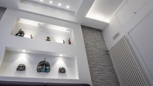 Un interior moderno con iluminación empotrada, pared de piedra y techo blanco.