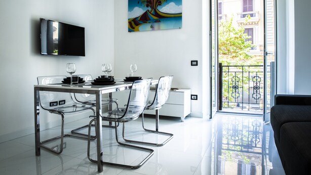 Una cocina moderna con una mesa de comedor, sillas y un televisor de pantalla plana.