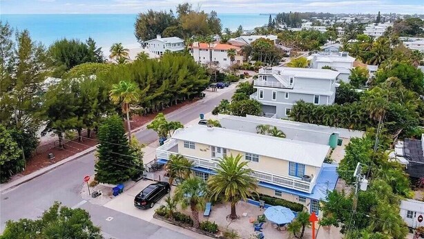 A coastal residential area with houses, a stop sign, and a car parked on the street. - LOCATION!! Cabana just steps from the beach! (Holmes Beach)