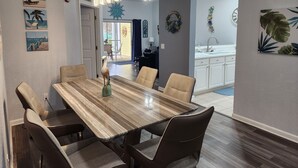 Un coin repas avec une table et des chaises en bois, une sculpture d’oiseau décorative et des œuvres d’art murales.