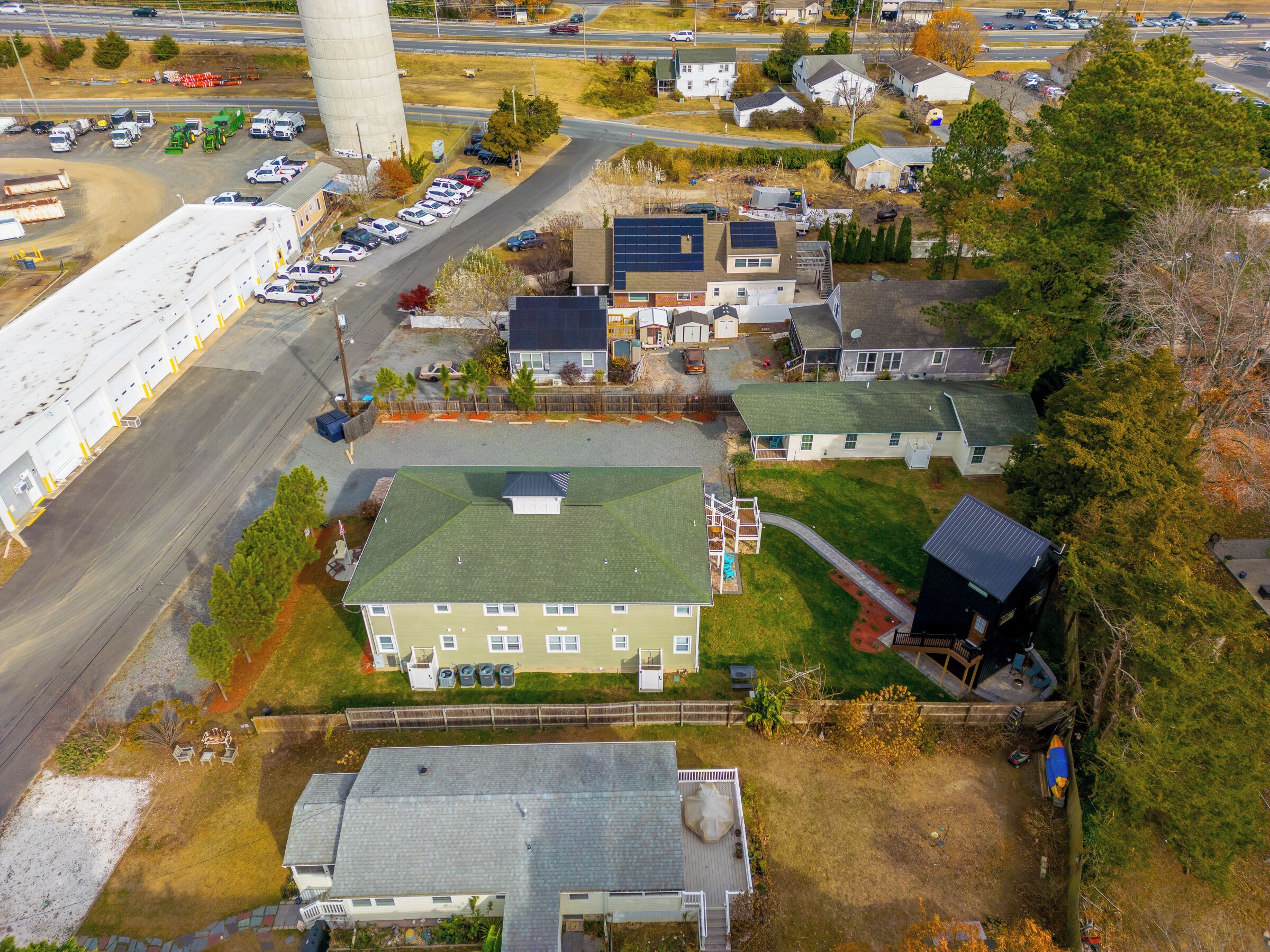 Luchtbeeld van een woongebied met huizen, een groot industrieel gebouw en een parkeerplaats.