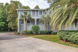 A two-story building with a symmetrical facade, a covered front porch, and a well-maintained lawn.