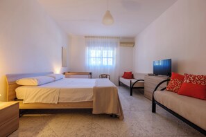 A bedroom with a bed, bedside table, chair, sofa, TV, and window with curtains. - Villa in Salento - Private Pool - 24/7 Support (Mesagne)