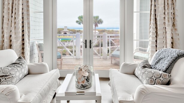 A white-framed glass door leading to a balcony with a view of the beach and palm trees. - Direct Beach/Pool Access from Watersound Condo - Comp Bikes, Boards, Beach Gear! (Watersound)
