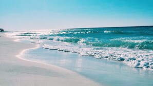 A beach with a clear sky and sunlight reflecting on the water. - Direct Beach/Pool Access from Watersound Condo - Comp Bikes, Boards, Beach Gear! (Watersound)