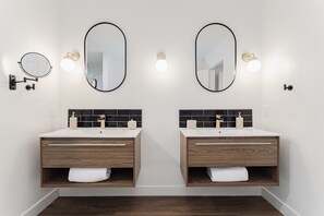 A bathroom with two sinks, each with a mirror above. There are wall-mounted lights and a towel rack. - Shuffleboard/Swimming Pool/BBQ Grill, 4 Miles To The Strip, Pet Friendly! (Las Vegas)