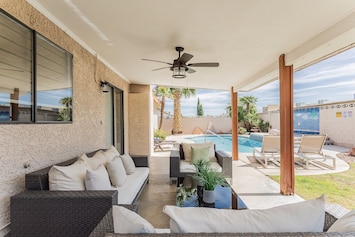 Large backyard with plenty of patio seats and a private swimming pool