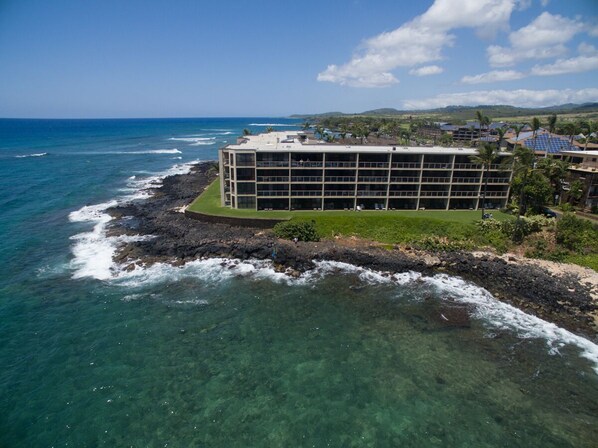 A coastal hotel with a clear view of the ocean and a rocky shoreline. - Ocean Front Condo with AC, enjoy the ocean from your own private lanai. (Koloa)