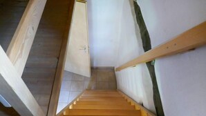 A wooden staircase with a handrail, leading to a door at the top. - Rustico Dolomia by Interhome (Olivone)