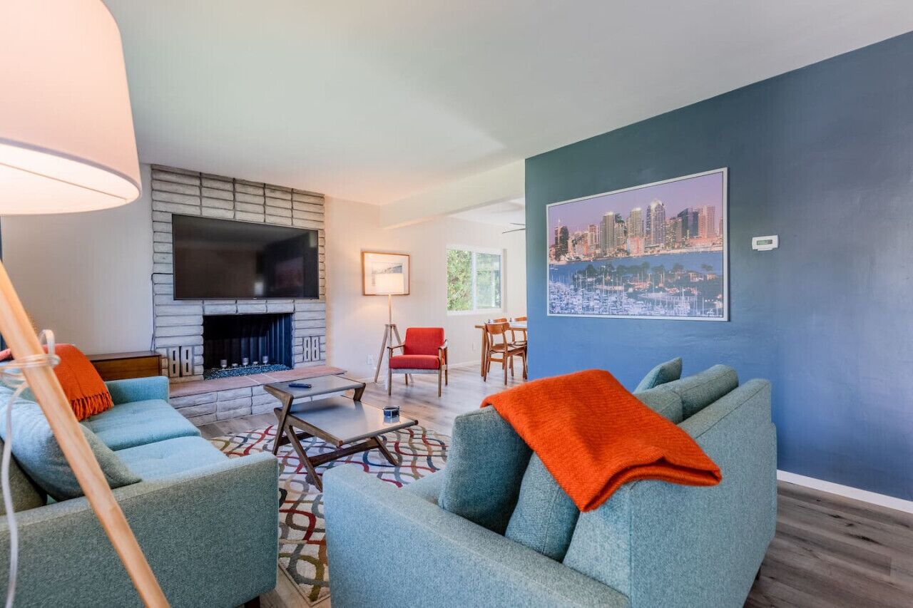 A modern living room with a fireplace, a large TV, and comfortable seating.