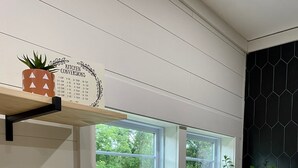 Cocina con encimeras de madera, un lavamanos blanco y una ventana con vistas a zonas verdes.