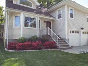 A two-story house with a front porch, a staircase, and a garage.