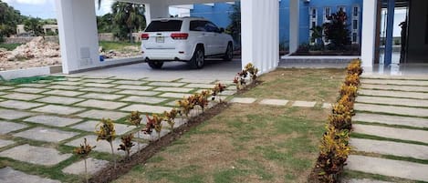 Guests can park their vehicle under the covered area and enjoy the beautifully maintained garden.