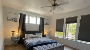 A bedroom with a bed, bedside tables, a ceiling fan, and large windows with blinds. - Family friendly Grover Beach house located blocks from the ocean.    (Grover Beach)