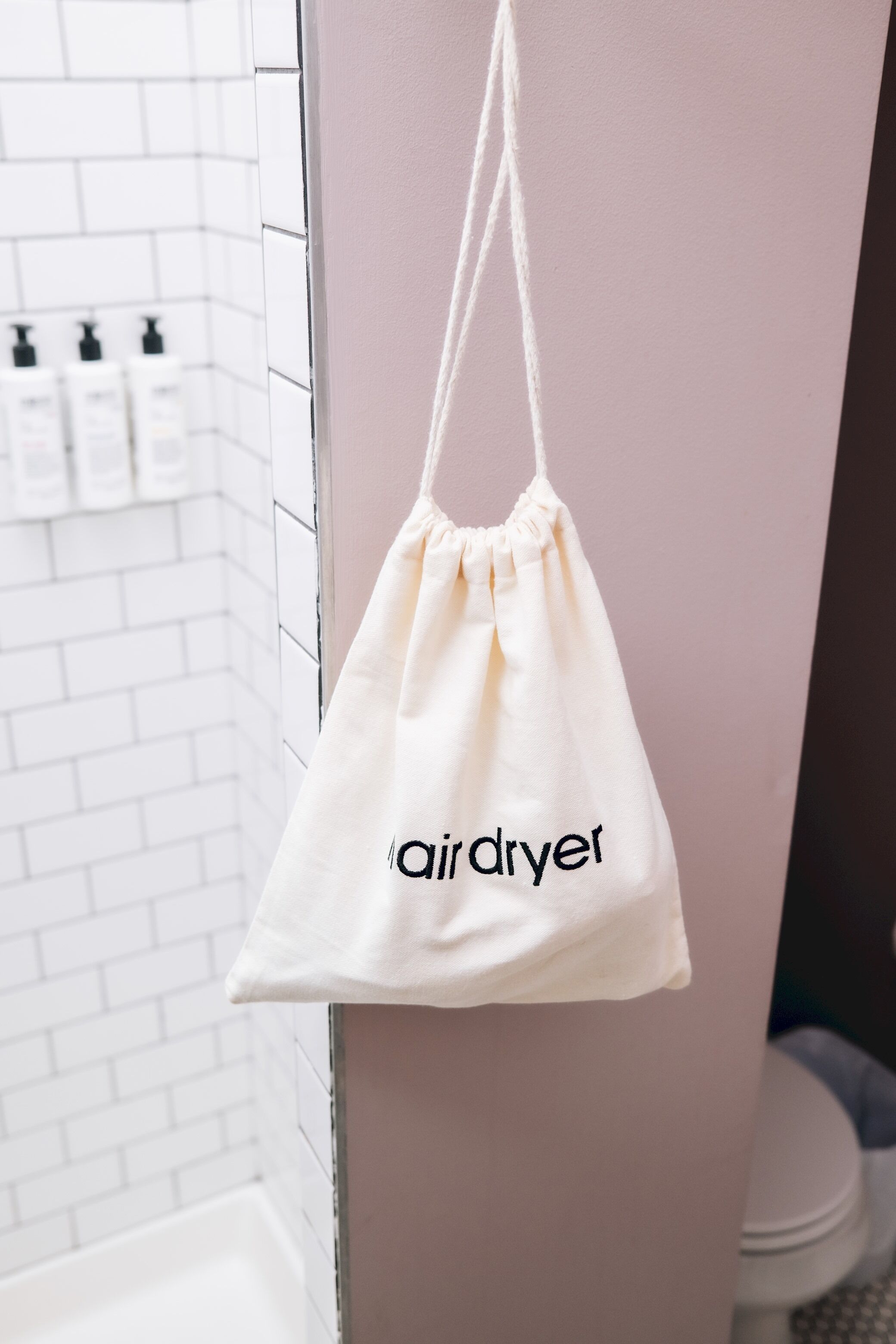 Una bolsa blanca con cordón colgando de una puerta, con el texto "airdryet".
