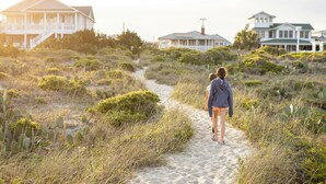 A pathway leading to a beachfront property with multiple houses.