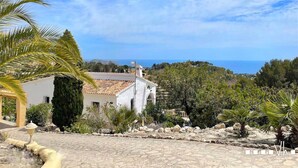 A coastal view with a white building, palm trees, and a clear sky. - Villa EL HORIZONTE in Benissa – For 4 people with sea views, swimming pool and barbecue (Benissa)