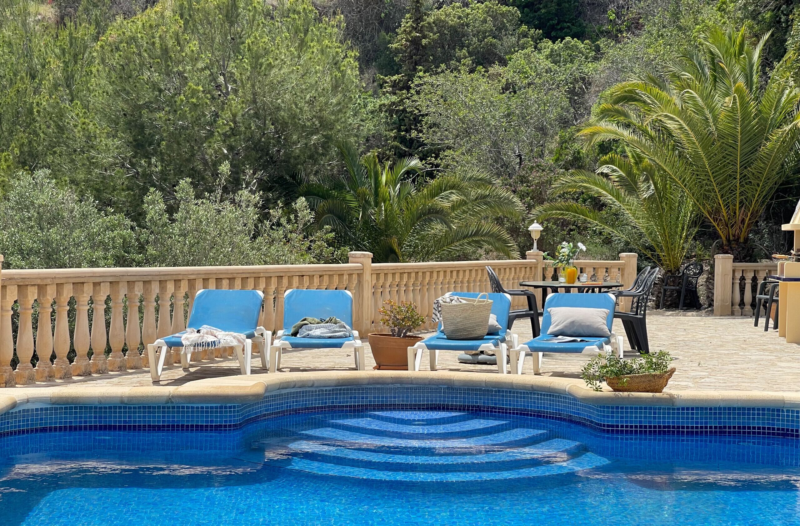 Un espace aménagé au bord de la piscine, avec des chaises longues et une piscine carrelée.