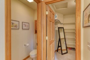 A bathroom with a toilet, a framed floral artwork, and a mirror leaning against the wall. - Pet Friendly!  Fireplace, Fenced Yard, Mountain Views, Near Hot Springs (Pagosa Springs)