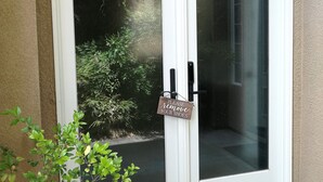 A front door with a 'Please remove your shoes' sign, a 'Welcome' mat, and a small plant beside it. - The Library (Dublin)