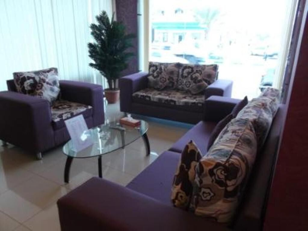 A living room with a sofa set, a coffee table, and a potted plant.