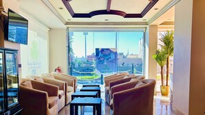 Eine großzügige Lobby mit modernem Deckenstil, bequemen Sitzgelegenheiten und einem großen Fenster mit Blick auf die Stadtlandschaft.