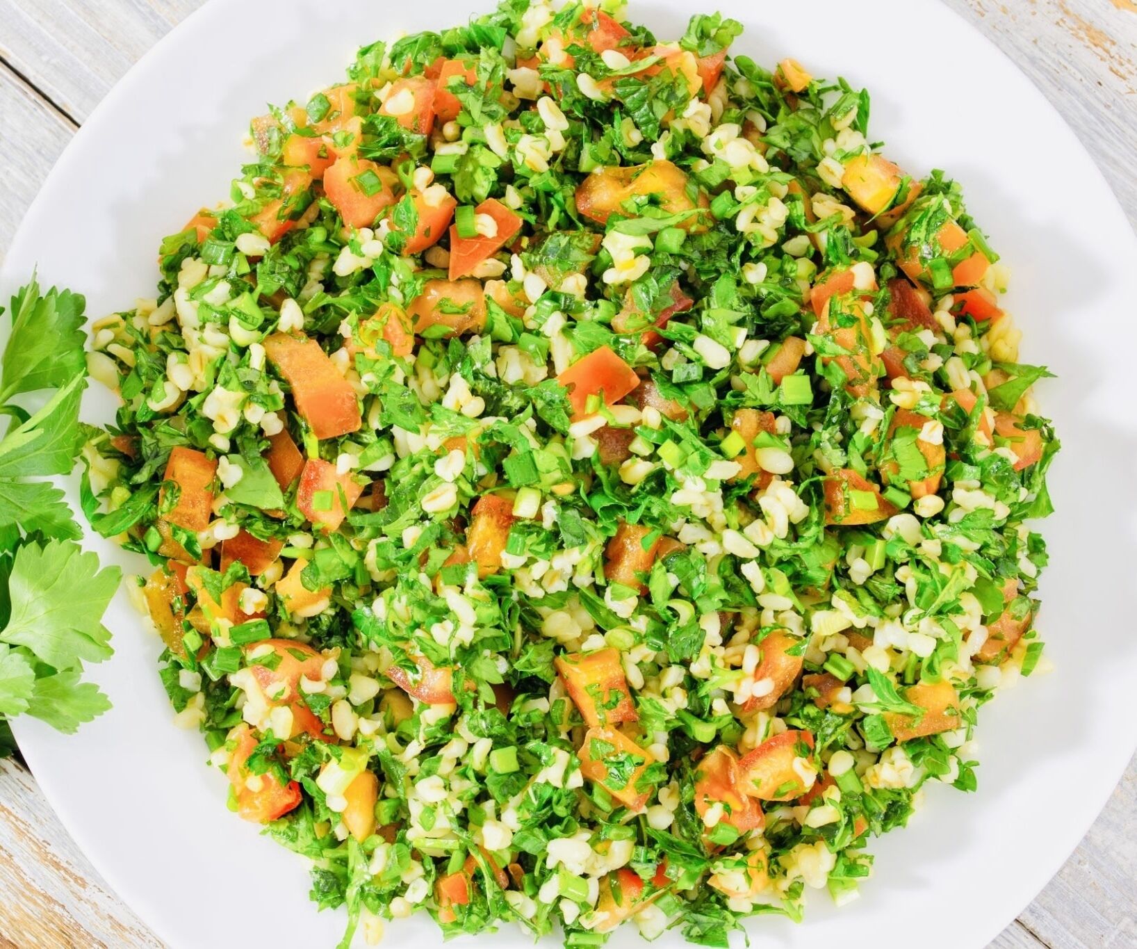 Un plato de ensalada mixta con diferentes verduras y cereales.