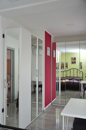 Une chambre comprenant un lit, un bureau et une armoire avec des portes coulissantes.
