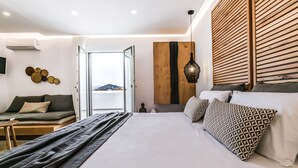 Un dormitorio moderno con una cama grande, un sofá, un revestimiento de listones de madera y vistas al exterior.