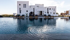 Un edificio blanco moderno con una piscina delantera.