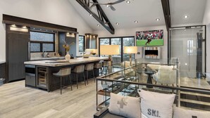 A modern kitchen with a large island, bar stools, and a glass dining area. - The Ontario | 5BR Epic Views, Heart of Park City (Park City)