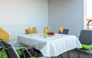 Ein Tisch gedeckt mit drei Gläsern eines gelben Getränks, einem grünen Trunk und einem Teller mit Wassermelone und Trauben.