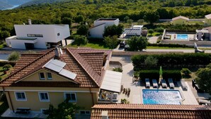 Un barrio residencial con casas modernas, una piscina y vistas a las montañas.
