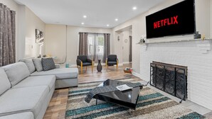 Una sala de estar moderna con un sofá seccional, una mesa de centro y una chimenea.