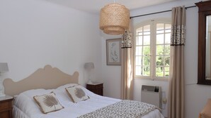 A bedroom with a bed, bedside lamps, a window with curtains, and a radiator. - Villa Provencale Face AU Luberon (Cabrières-d'Avignon)