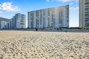 A sandy beach with high-rise buildings in the background. - XPLORIE ACTIVITIES & LINENS INCLUDED*! Plaza 2BR/den on the oceanfront! (Ocean City)