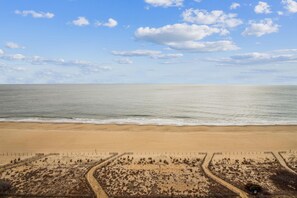 Une plage avec un ciel dégagé et une mer calme.