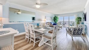 A dining area with a table set for four, surrounded by white chairs with cushioned seats. - This absolutely beautiful 3 bedroom, 2 bath condo completely remodeled into a stunning beach home. (Ocean City)