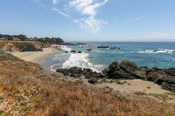 A coastal landscape with a beach, rocky shoreline, and ocean waves. - Kyuka | Asian-Inspired Coastal Retreat (Sea Ranch)