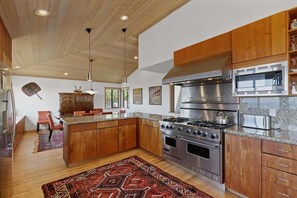 A modern kitchen with wooden cabinets, stainless steel appliances, and a central island.