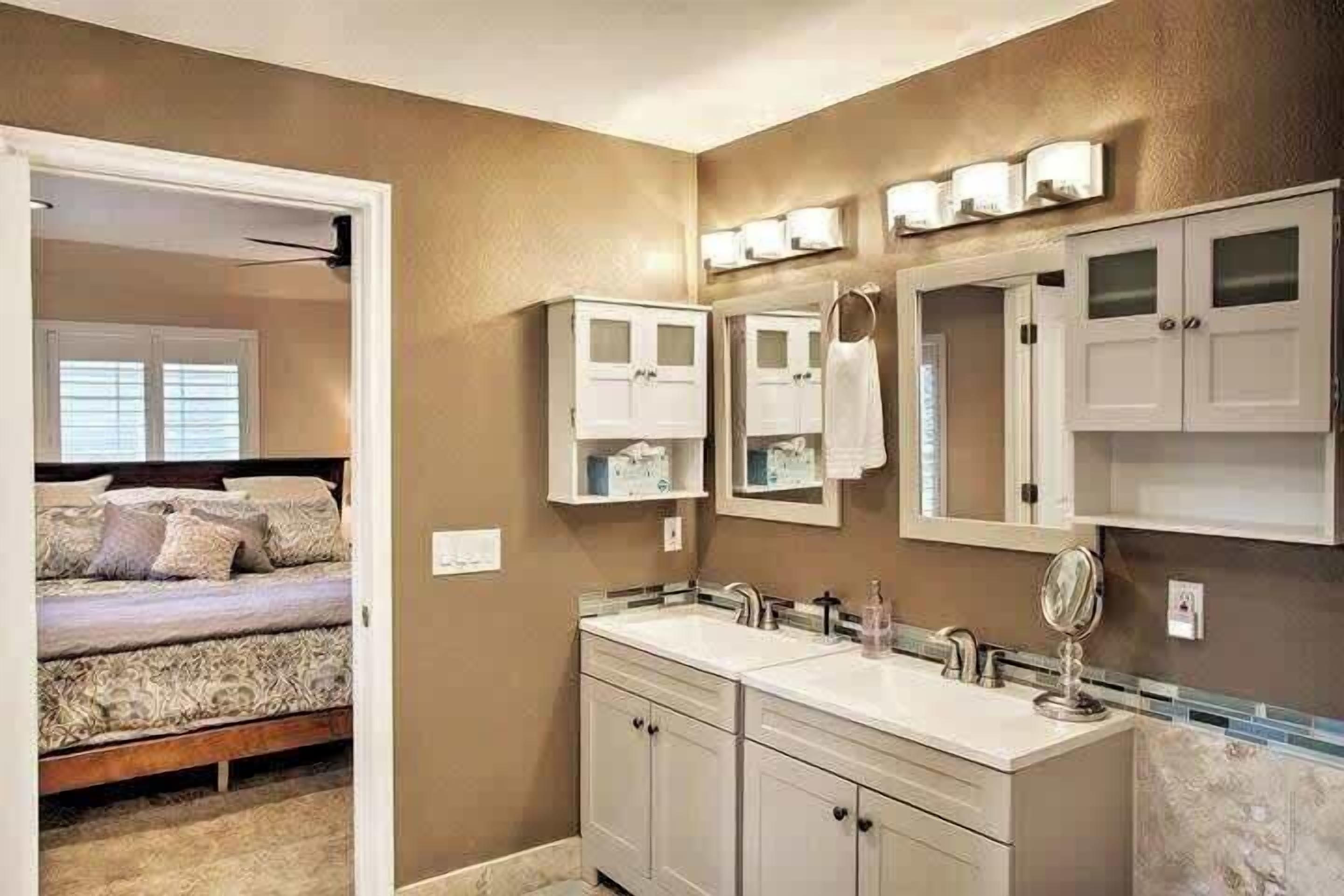 Une salle de bain avec un double lavabo, un meuble-lavabo et un grand miroir.