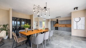 Una cocina moderna con gabinetes grises, encimera de madera y extractor de aire negro.